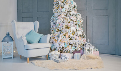 beautiful stylish interior in blue gray and white tones with a white Christmas tree and a comfortable armchair. Merry Christmas and Happy new year mood vibes