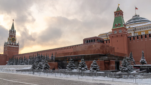 View of the Kremlin Wall in winter in Moscow. The mausoleum near the Kremlin on Red Square. Snow-covered fir trees in front of the Moscow Kremlin. The Red Square.
