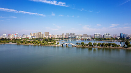 Obraz premium Serene Urban Landscape with Lush Park and Tranquil River View
