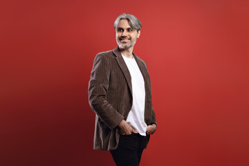 man smiling with hands in pocket and looking to the side