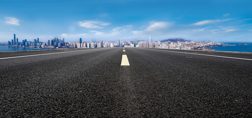 Open Highway Leading to a Vibrant City Skyline Under a Clear Blue Sky