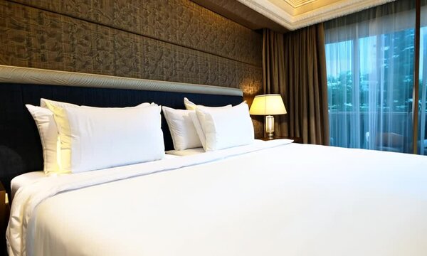 : A spacious hotel room featuring a large bed with crisp white linens,.