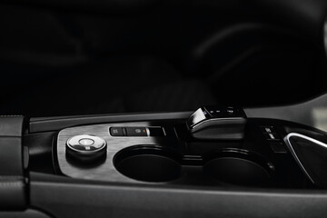 Modern car center console with electronic gear selector, stylish design, and control buttons. Ideal...