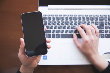 woman hand smart phone with computer on office