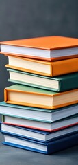Naklejka premium Stack of colorful books on a dark background, perfect for educational themes.