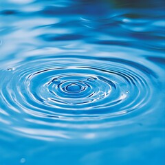 Concentric Circles. Tranquil blue water ripples with drops, abstract background texture.