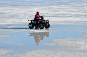 Quad bike ride in a frozen lake in winter © labalajadia