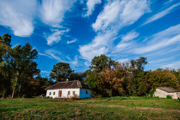 Traditional rural house with a thatched roof is nestled in a peaceful countryside