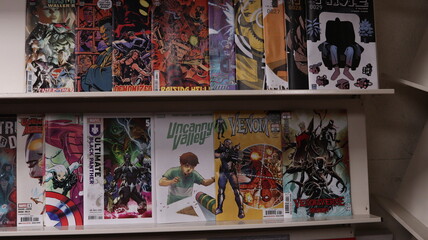 Obraz premium CARDIFF, MID GLAMORGAN, WALES UK - OCTOBER 3, 2024: COMIC BOOKS ON SHELVES DISPLAY PAPERBACKS 