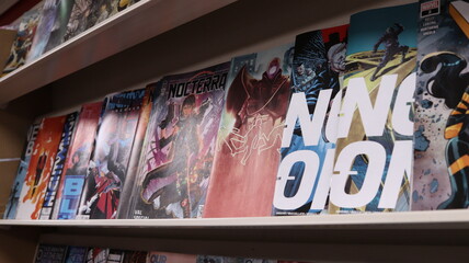 Obraz premium CARDIFF, MID GLAMORGAN, WALES UK - OCTOBER 3, 2024: COMIC BOOKS ON SHELVES DISPLAY PAPERBACKS 