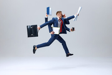 Businessman in mid-leap, arms full of briefcase, coffee, and documents, capturing essence of busy...