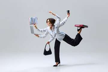 Woman in professional attire with multiple arms, managing laptop, phone, documents, and coffee....