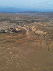 Aerial views of Patagonia, Argentina, featuring barren wastelands, rugged mountains, and dry plains. The photos capture the vast, remote wilderness, highlighting the dramatic Andean peaks.