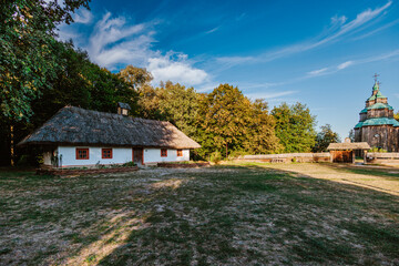 Scene featuring a traditional thatched-roof house with whitewashed walls