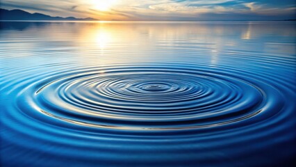 Ripples Expanding on Calm Water at Sunset, Reflecting the Sky and Mountains in the Distance