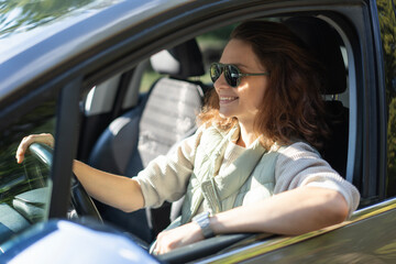 Young happy woman sitting in her car