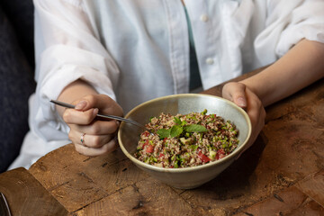 Tabbouleh salad in a bowl on a wooden table .quinoa salad