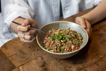 Tabbouleh salad in a bowl on a wooden table .quinoa salad