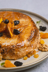 cake with dried apricots, raisins and walnuts on grey background