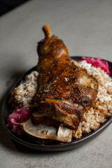 Leg of lamb with rice and red onion on gray background