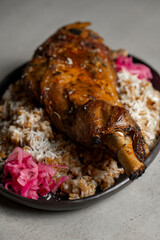 Leg of lamb with rice and red onion on gray background