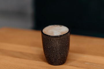 Celebrate the artistry of coffee with a delicate leaf design in the foam, served in a rustic cup