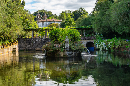 Beautiful lake with swans and flowering plants in the gardens of the Pazo de Oca, Galicia.