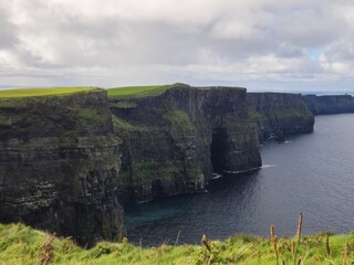 Dramatic Green Cliffs Of Moher Overlooking The Ocean Waves In Ireland