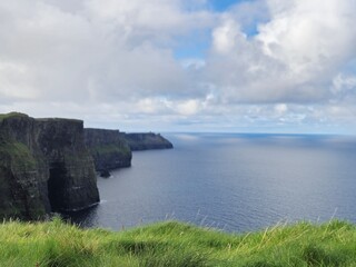 Dramatic Cliffs Of Moher: A Coastal Landscape Of Green Cliffs And Ocean Waves