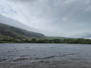 Serene Waterscape: Reflections And Little Waves Beneath Clouded Skies
