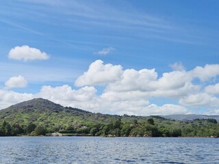 Serene Riverside Landscape With Reflective Clouds And Gentle Waves