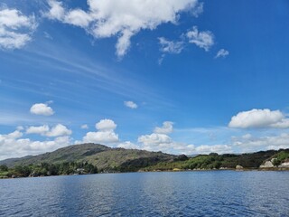 Tranquil Waterscape: Serene River With Cloud Reflections And Little Waves