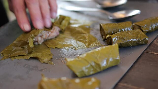 People cook dolma food.
Grape leaves stuffed with minced meat.