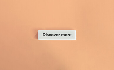 Discover More Phrase. Text on Block Letter Tile on Dusty Pink Background. Minimal Aesthetic.