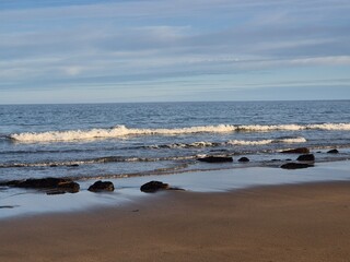 Summer Serenity: Waves Crashing On A Sunlit Coastal Beach