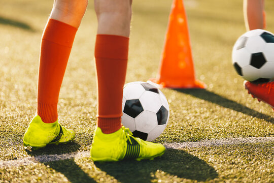 Soccer player practicing dribbling with friends in a team. Group of school teenagers kicking soccer balls during an autumn training session. Boys in football club improving ball possession skills