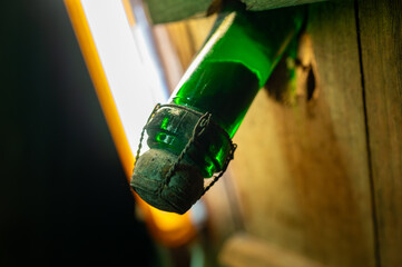 Champagne bottles on pupitre riddling racks in deep and long underground caves, making champagne...