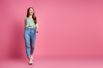 Full body portrait of pretty young girl walk look empty space wear top isolated on pink color background