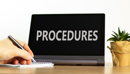 Procedures symbol. Concept word Procedures on beautiful black tablet. Beautiful wooden table white background. Businessman hand with pen. Business procedures concept. Copy space.