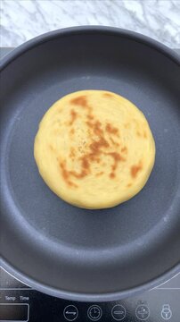 Making an arepas or tortillas on a hot non stick pan.