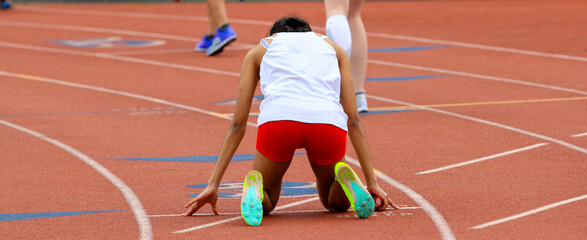 Runner in the on your mark position ready to start a track relay race