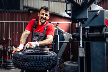 Portrait of caucasian tire repairman preparing wheel for mounting.