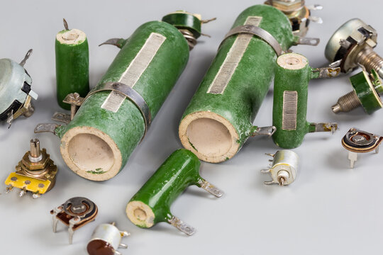 Old different fixed, variable and adjustable resistors on a gray surface