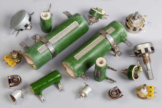 Old different fixed, variable and adjustable resistors on a gray surface