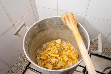 Traditional Portuguese kitchen with a pot on the stove, simmering a classic sauté. A wooden spoon rests on top, capturing the essence of home-cooked comfort.