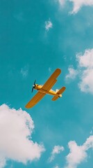 A vibrant yellow airplane soaring through a clear blue sky, surrounded by fluffy white clouds, capturing a moment of flight.