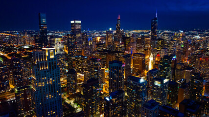 Light streets and buildings of modern Chicago at night. Thriving vibrant metropolis view from top.