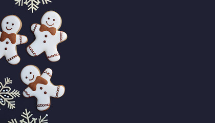 Christmas gingerbread men on dark blue background with copy space, top view