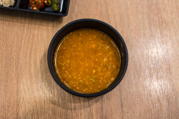 Sukiyaki dipping sauce with white sesame in black bowl