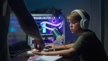 One of parents compels child to complete their homework by directing their attention to textbooks and notebook, rather than engaging in recreational activities on gaming computer.